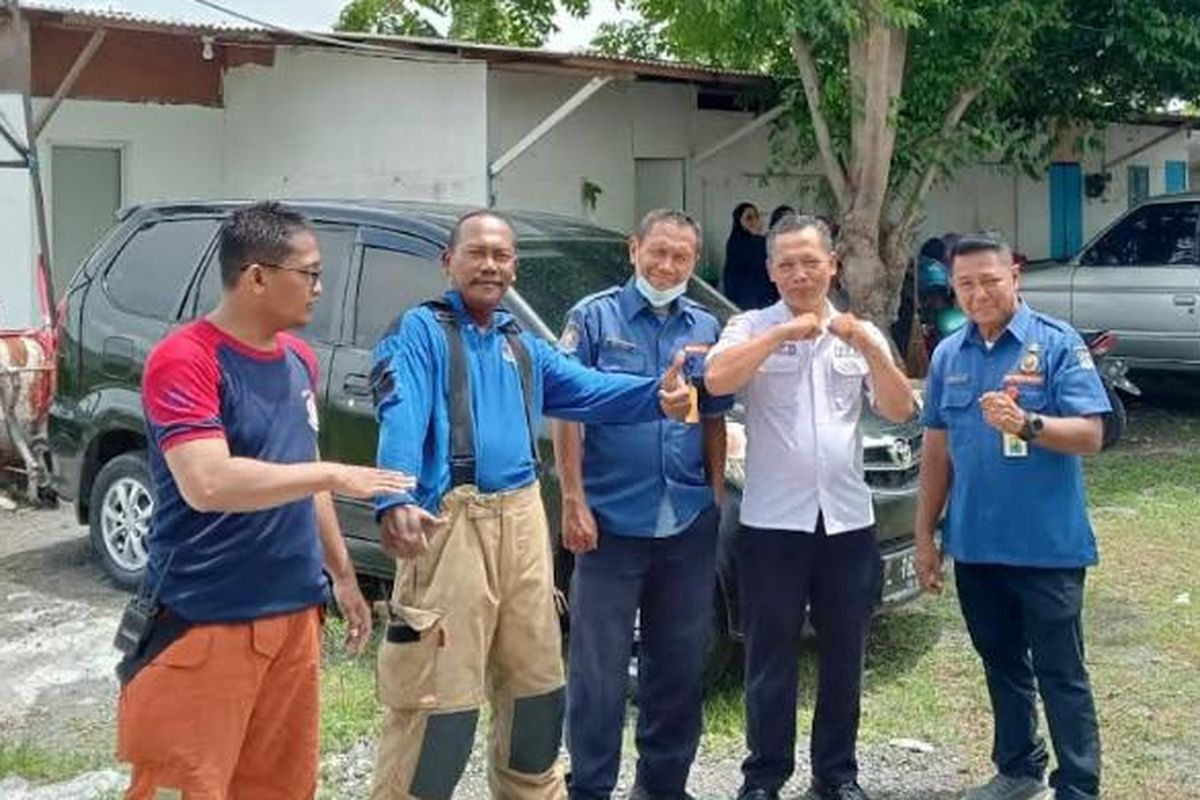 Komandan Regu Pemadam Kebakaran Pos Kandangan, Edi (dua dari kiri) terkapar tiba-tiba akibat kena aliran listrik di bangunan rumah yang terbakar di Benowo, Surabaya.