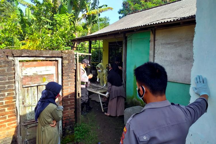 Polisi dan petugas kesehatan bersiap membawa jasad Sarjito yang ditemukan tewas di rumahnya di Kecamatan Selopuro, Kabupaten Blitar, Jawa Timur, Minggu (27/3/2021) 