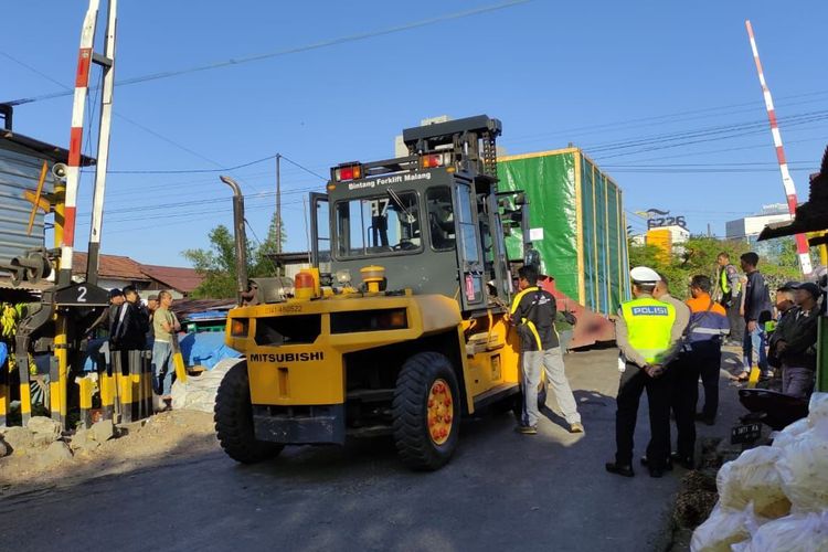 Proses evakuasi truk panjang bermuatan mesin yang tersangkut di perlintasan sebidang Kereta Api (KA) di Jalan Industri Barat, Kota Malang, Jawa Timur pada Jumat (22/9/2023).