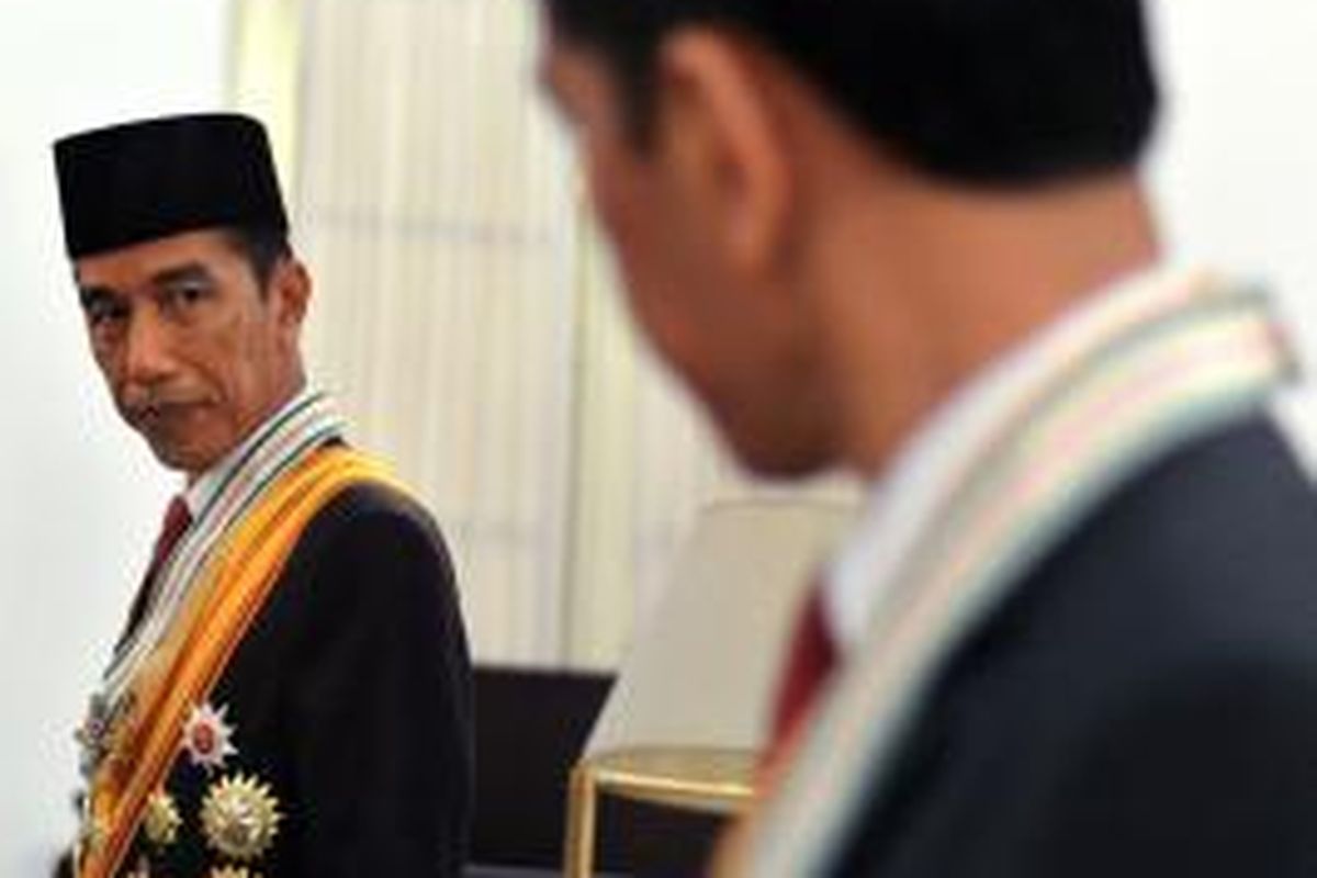 In this handout photograph taken on October 22, 2014 and released by the presidential palace on October 25, 2014, Indonesian President Joko Widodo prepares for an official portrait session at the presidential palace in Jakarta.  Joko Widodo, 53, popularly known by his nickname Jokowi was inaugurated as Indonesia's president October 20, capping a remarkable rise from an upbringing in a riverside slum.    AFP PHOTO / SETNEG / CAHYO BRURI SASMITO