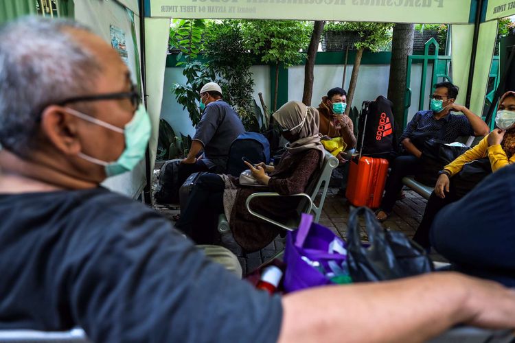 Pasien positif Covid-19 orang tanpa gejala (OTG) di Puskesmas Kecamatan Tebet, menunggu mobil ambulans dan bus sekolah untuk di karantina di Rumah Sakit Darurat Wisma Atlet, Kamis (17/9/2020). Pemerintah Provinsi DKI Jakarta mengetatkan kembali pembatasan sosial berskala besar, per senin 14 september. Pasien positif Covid-19 tanpa gejala (orang tanpa gejala/OTG) yang sebelumnya bisa menjalani isolasi mandiri di rumah, saat ini harus dikarantina di tempat isolasi pemerintah, seperti di Rumah Sakit Darurat Wisma Atlet.