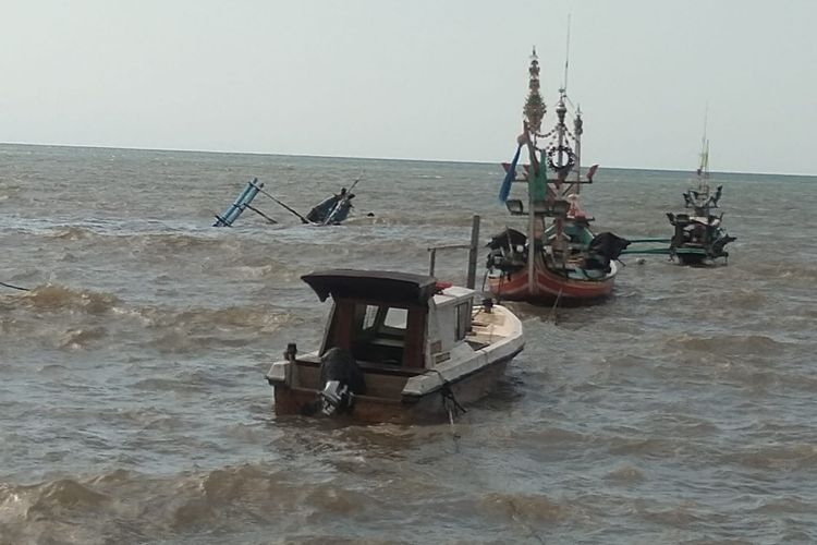 Perahu nelayan terlihat tenggelam terbawa ombak di perairan Muncar 