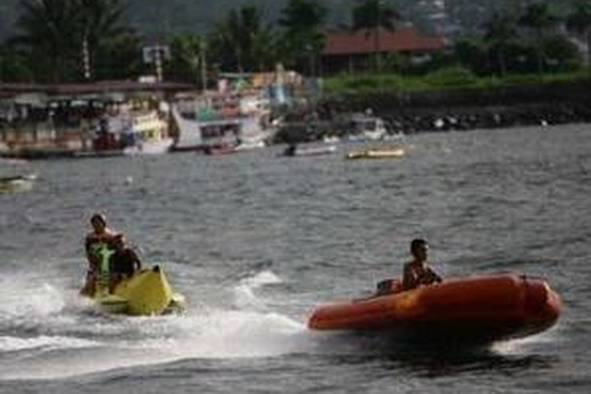 Wisatawan mencoba banana boat yang disewakan di sekitar lokasi wisata Pantai Boulevard di Teluk Manado, Sulawesi Utara. Pantai Manado merupakan salah satu lokasi wisata bahari populer. 