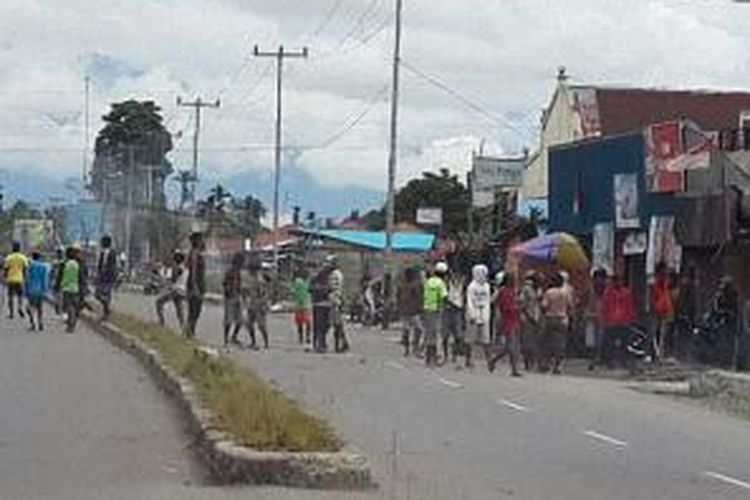 puluhan warga bersenjata tajam berkerumun di Jalan Yos Sudarso Timika. Bentrok antara dua kelompok warga asal kampung Holat dan Kampung Bombay dari Maluku Tenggara di Timika menyusul pembunuhan terhadap tokoh masyarakat kampung Bombay di Jalan Pattimura, Minggu (9/2/2014) lalu.