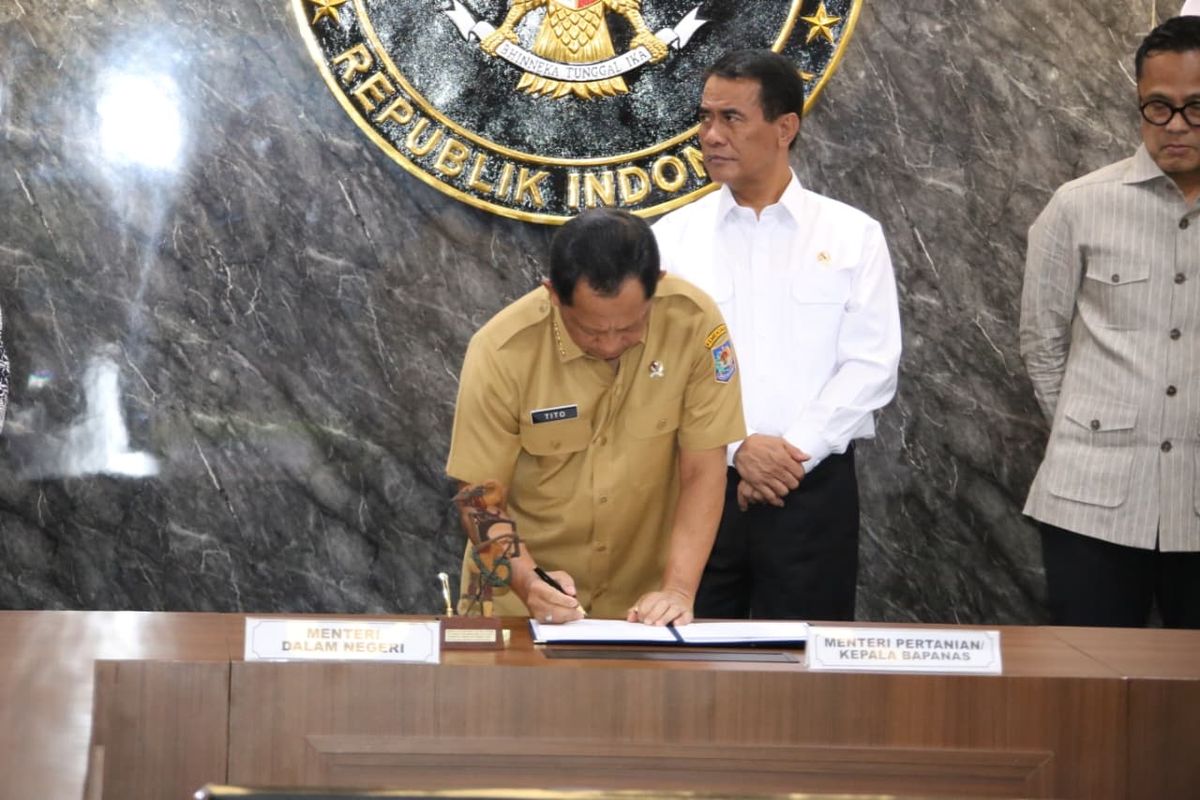 Menteri Dalam Negeri (Mendagri) Muhammad Tito Karnavian saat menandatangani Surat Keputusan Bersama (SKB) tentang Penugasan Percepatan Penyediaan Infrastruktur Pascapanen di Kantor Kementerian Koordinator (Kemenko) Bidang Pangan, Jakarta, Selasa (11/11/2025).