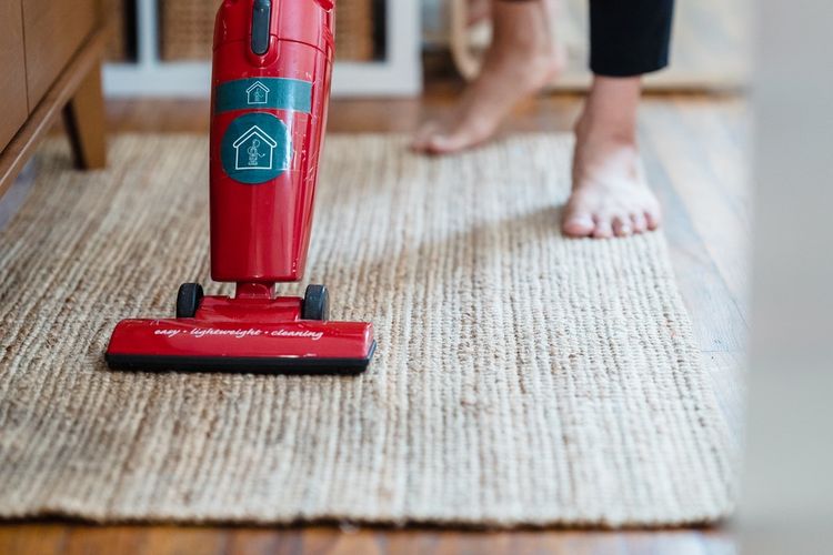 Iluatrasi membersihkan karpet dengan vacuum cleaner. 