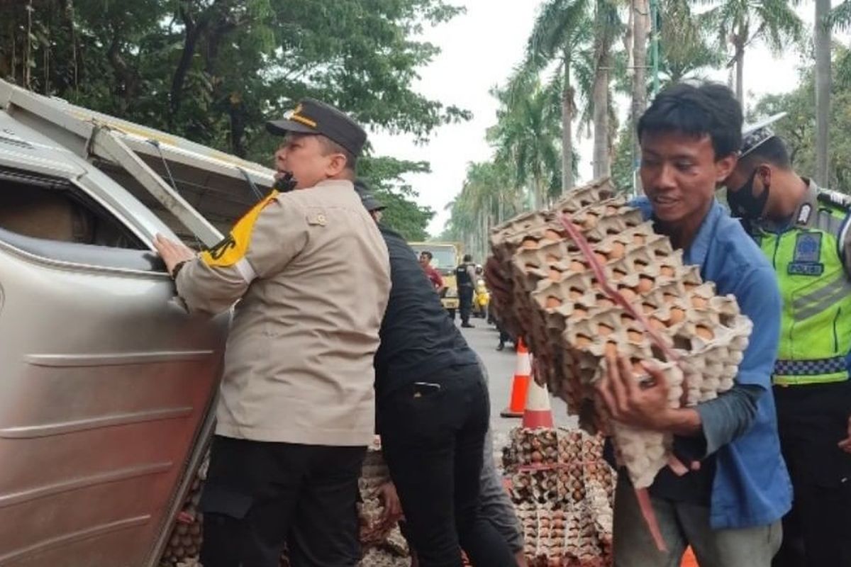 Petugas dan warga mengevakuasi mobil pikap bermuatan telur yang menabrak satu gerobak buah dan satu unit sepeda motor di Jalan Ki Hajar Dewantara, Cikarang, Kabupaten Bekasi, Senin (10/10/2022) sore. Insiden itu diduga terjadi akibat mobil yang oleng saat pengemudinya berkendara dalam kecepatan tinggi. 