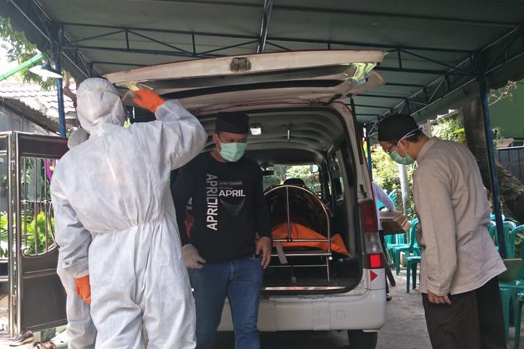 Pasien dengan status virus corona yang sempat dirawat di Rumah Sakit Dr Hafiz (RSDH) Cianjur, Jawa Barat, meninggal dunia. Jenazah diantar dengan ambulans RSDH, menuju kediaman di kawasan Tambun, Bekasi, Jawa Barat, Selasa (3/3/2020). Para petugas tampak mengenakan alat pelindung diri khusus. Sementara, jenazah diletakkan di dalam kantong jenazah bewarna oranye.