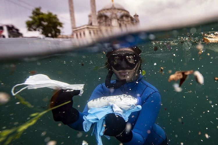 Atlet selam bebas Turki Sahika Ercumen yang menjadi duta kehidupan bawah laut dari PBB menunjukkan sampah plastik berupa sarung tangan plastik, masker wajah dan botol disinfektan yang banyak mencemari laut di Selat Bosphorus pada 1 Juli lalu.