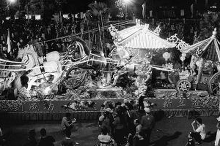 Salah satu kendaraan yang dihias dengan patung kuda kayu, lampu-lampu, dan bunga sakura pada malam pawai lampion di Kota Singkawang, Kalimantan Barat, Rabu (12/2/2014) malam.