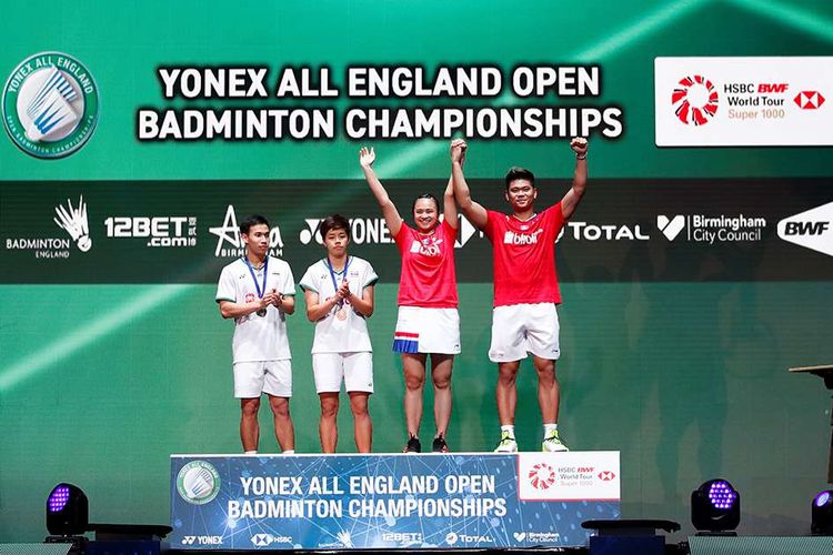 Pebulu tangkis ganda campuran Indonesia Praveen Jordan dan Melati Daeva Oktavianti mengangkat tangan di podium usai memenangi laga final ganda campuran All England melawan pebulu tangkis Thailand Dechapol Puavaranukroh dan Sapsiree Taerattanachai di Arena Birmingham, Inggris, Minggu (15/3/2020). Praveen/Melati berhasil menjadi juara All England setelah memenangi pertandingan dengan skor 21-15, 17-21, dan 21-8.