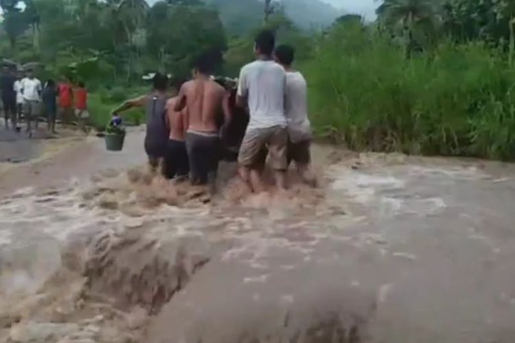 Foto: Warga berjibaku pikul kendaraan roda dua melintasi Kali Loworegi di Kecamatan Paga, Kabupaten Sikka, NTT yang sedang banjir, Senin (28/11/2022).