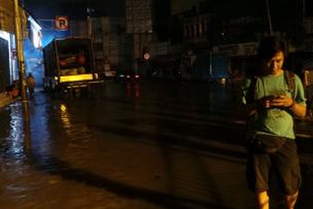 Jalan Jatinegara Barat mulai diluapi air dari permukaan Ciliwung. Senin (13/1/2014).