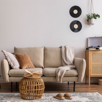 Ilustrasi sofa warna krem atau beige di ruang tamu.
