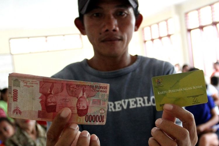 Seorang penerima dana BLSM di Manado menunjukkan Kartu Perlindungan Sosial dan dana yang diterimanya.