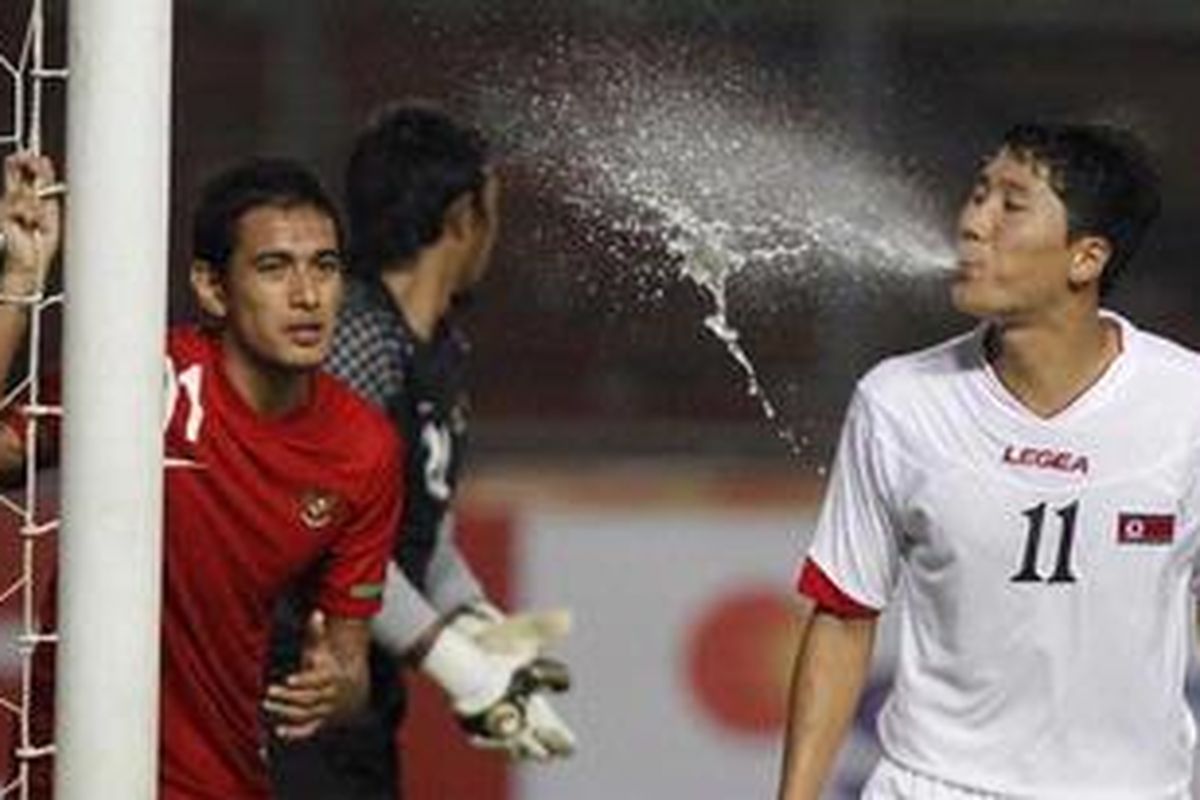 Pemain timnas Korea Utara, Jong Il Gwan menyemprotkan air mineral saat menunggu tendangan sudut yang dijaga kiper timnas Indonesia, Endra Prasetya dan Hengky Ardiles dalam turnamen SCTV Cup di Stadion Utama Gelora Bung Karno, Jakarta, Senin (10/9/2012).