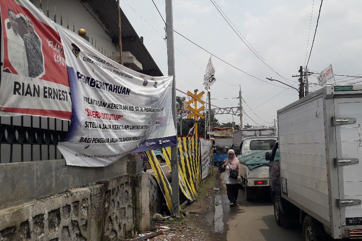 Kendaraan mengantre di perlintasan kereta api dekat Kantor Imigrasi Jakarta Timur, Jumat (5/4/2019).