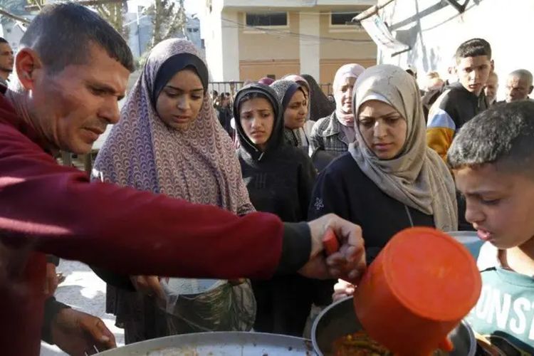 Warga Palestina mengantre untuk mendapatkan makanan dari organisasi bantuan.