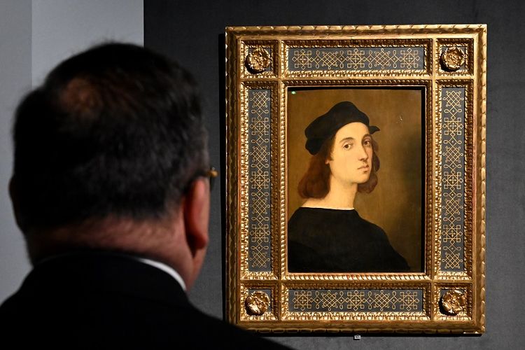 Seorang pengunjung melihat lukisan Potret Diri oleh master Renaissance Raffaello Sanzio da Urbino, yang dikenal sebagai Raphael, pada 4 Maret 2020, dipajang di pameran Raffaello di Scuderie del Quirinale di Roma.