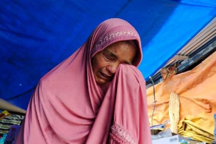 Siir (54) menghapus air matanya dengan jilbab karena menangis mengingat rumahnya yang roboh akibat gempa bumi di kampung Siparayo, Nagari Malampah, Kecamatan Tigo Nagari, Kabupaten Pasaman, Sumbar, Selasa (1/3/2022).