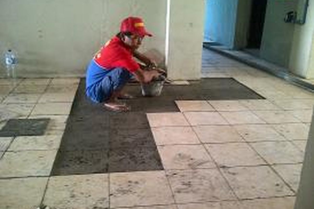 Seorang tukang sedang melakukan perbaikan pemasangan keramik di Rusun Pinus Elok, Cakung, Jakarta Timur, Senin (16/9/2013). Rusun tersebut akan dipersiapkan untuk warga Waduk Ria Rio yang akan direlokasi pada akhir bulan September 2013.