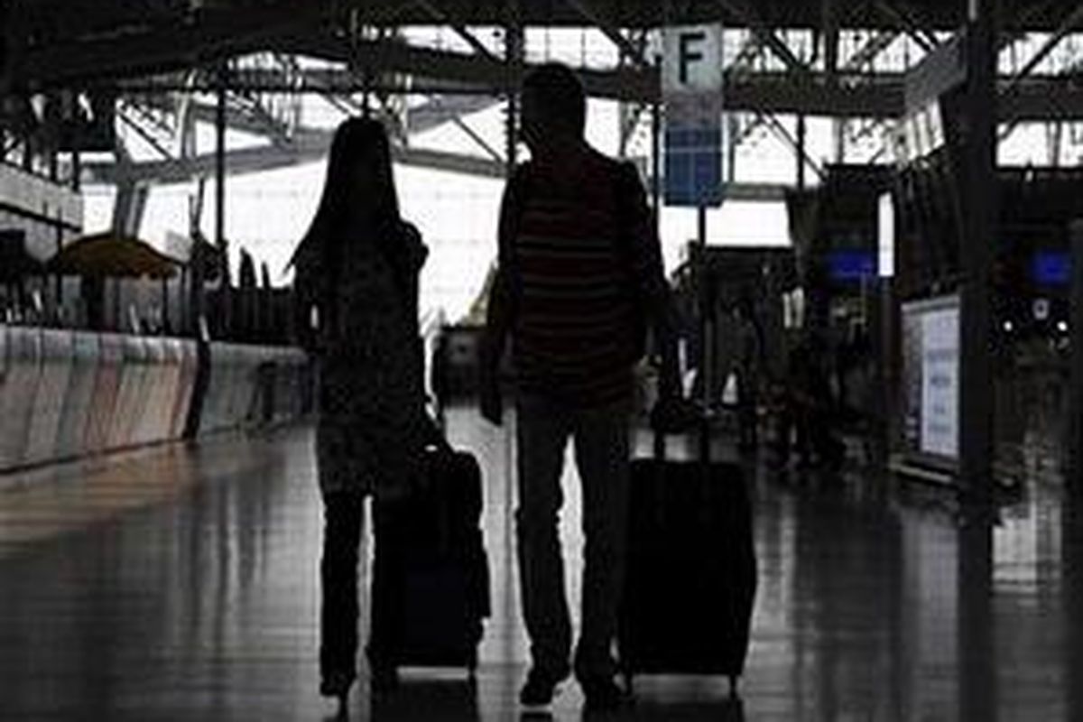 Beberapa calon penumpang berjalan menyusuri ruang keberangkatan Bandara Suvarnabhumi di Bangkok pada 4 Desember 2008. Thai Aiways berencana menuntut demonstran antipemerintah atas kerugian yang dialami selama unjuk rasa 8 hari yang mengakibatkan 2 bandara di Bangkok terhenti operasinya. 