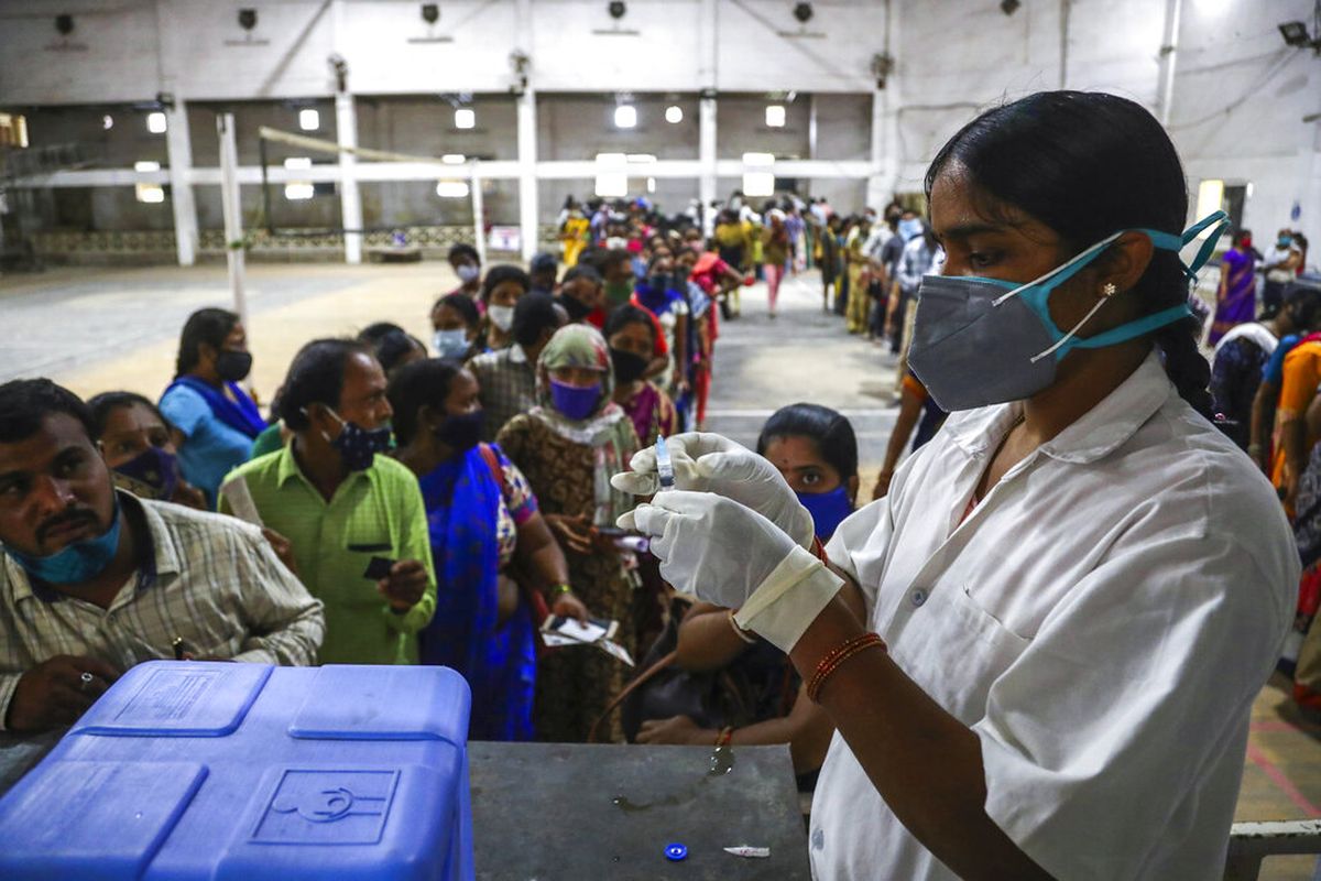 Seorang petugas kesehatan bersiap untuk memberikan dosis Covaxin ketika ratusan orang berbaris untuk menerima dosis kedua vaksin melawan virus corona di stadion kota di Hyderabad, India, Kamis, 29 Juli 2021. 