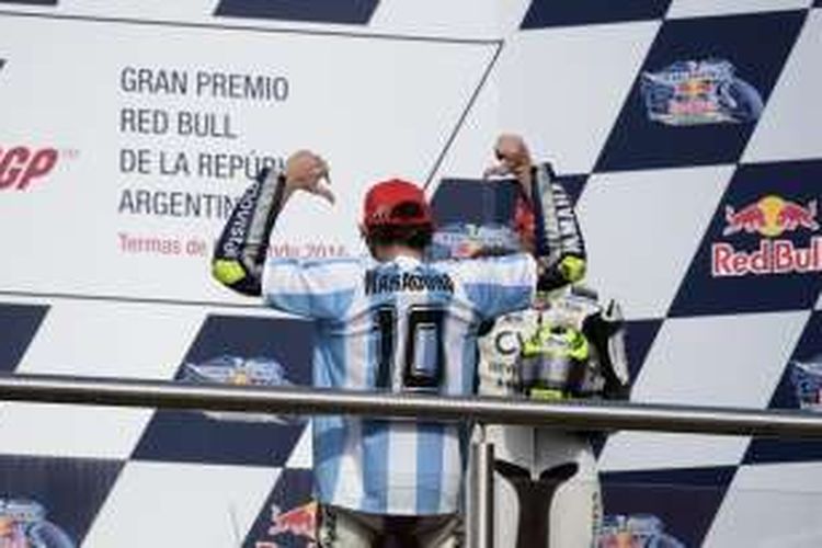 Pebalap Movistar Yamaha asal Italia, Valentino Rossi, merayakan kemenangan pada GP Argentina di Autodromo Termas de Rio Hondo dengan mengenakan baju bernomor punggung 10 milik legenda sepak bola Diego Maradona, Minggu (19/4/2015).