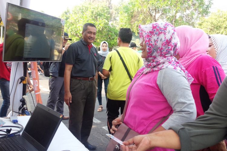  Para pejalan kaki di area car free day di Jalan KH Wahid Hasyim Jombang Jawa Timur, melakukan pengecekan DPT Pemilu 2019.