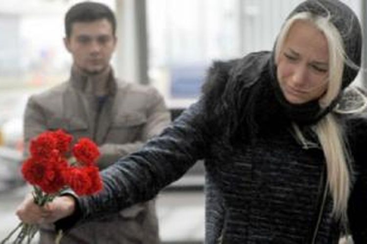 Seorang wanita menaruh karangan bunga di bandara internasional Pulkovo, St. Petersburg pada Minggu (1/10/2015), hari berkabung untuk korban pesawat jatuh di Mesir.