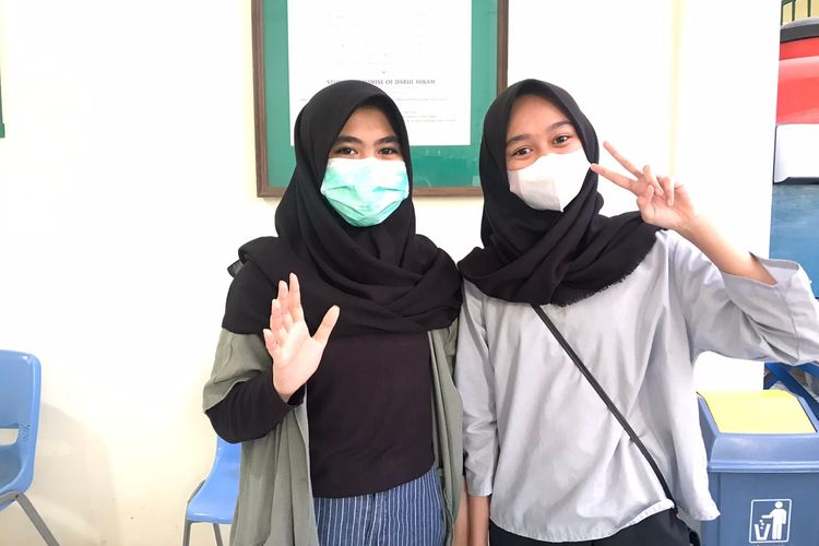 Kinan Annisa Jose (13) dan Ghea Nasywa Aulia (14), siswi SMP Darul Hikam saat mengikuti vaksinasi Covid-19 di sekolahnya. 