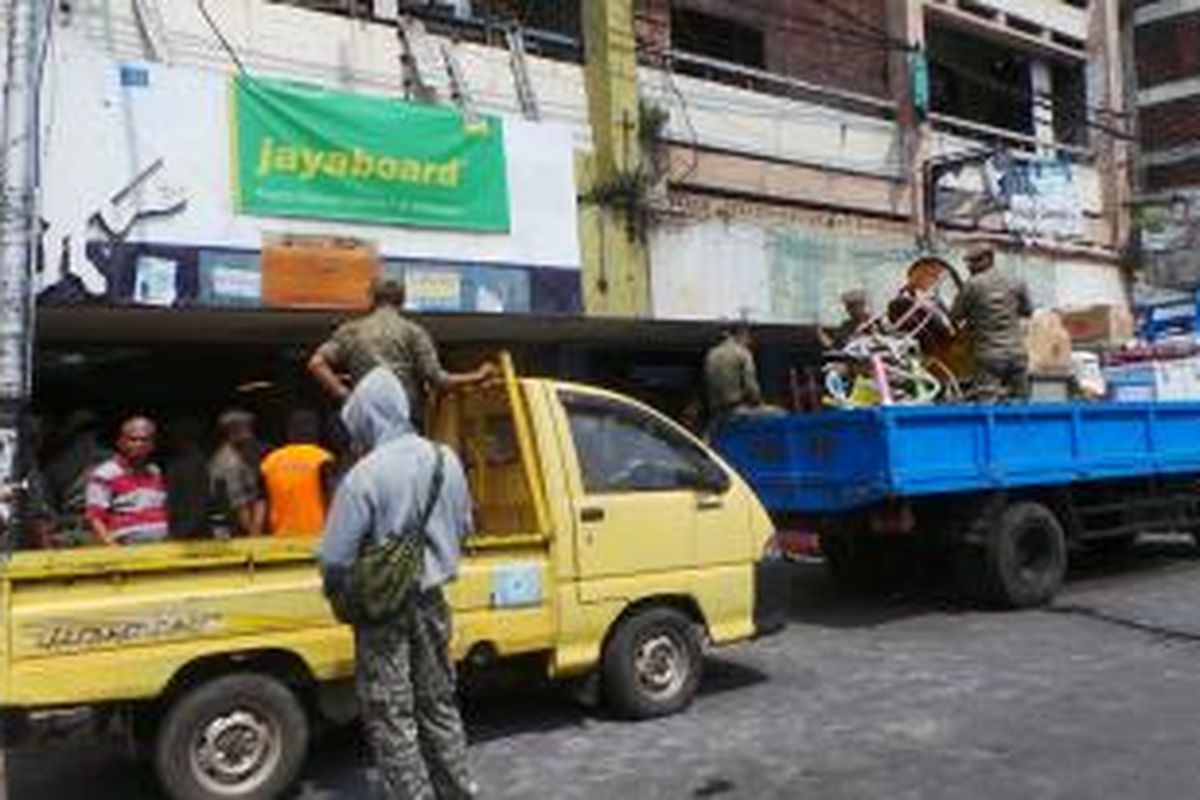 Petugas Satpol PP melakukan penertiban terhadap belasan toko di Jalan Jatinegara Barat, Jatinegara, Jakarta Timur. Rabu (27/8/2014).
