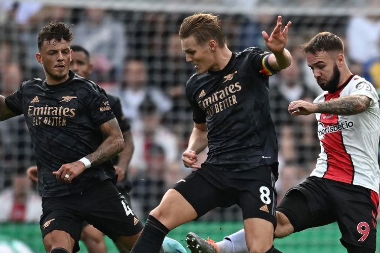 Gelandang Arsenal Martin Odegaard saat berusaha melewati striker Southampton Adam Armstrong pada laga lanjutan Liga Inggris 2022-2023. Laga Southampton vs Arsenal di St. Mary's Stadium, pada Minggu (23/10/2022) malam WIB itu berakhir dengan skor 1-1. (Photo by Ben Stansall / AFP)