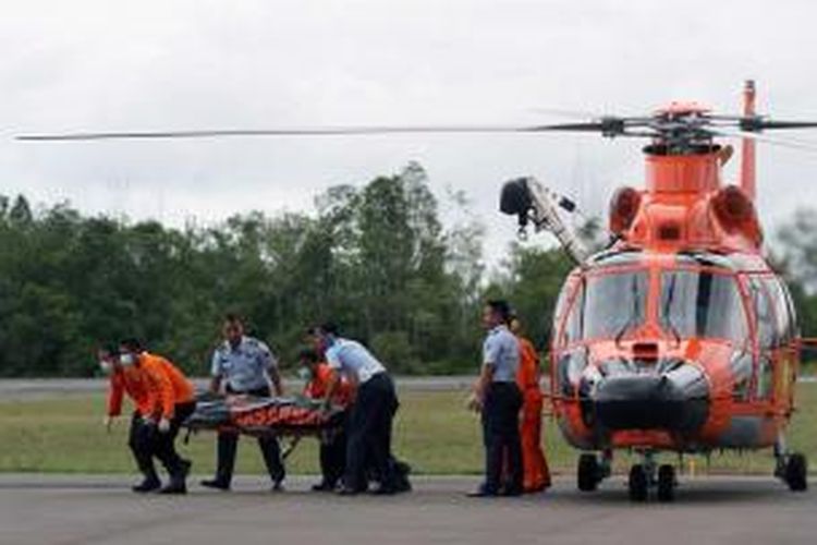 Petugas Basarnas membawa jenazah dari helikopter menuju ambulans di Posko Utama Pecarian Pesawat AirAsia QZ8501, Lanud Iskandar, Pangkalan Bun, Kalteng, Rabu (31/12/2014). Dua dari tujuh jenazah yang telah ditemukan dibawa ke posko untuk kemudian diidentifikasi di RSUD Sultan Imanudin.