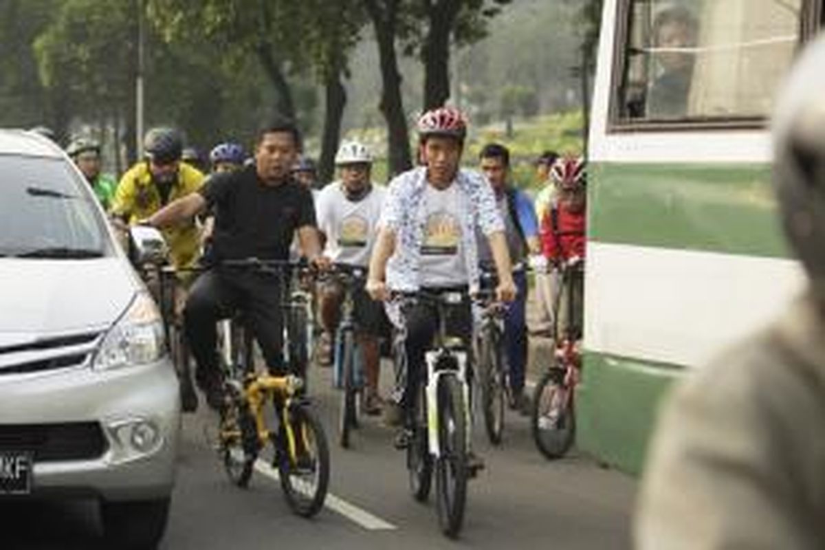 Gubernur DKI Jakarta, Joko Widodo bersama pegiat sepeda, bersepeda melewati kepadatan kendaraan di Jalan Gatot Subroto, Jakarta, Jumat (28/2/2014). Bersepeda menuju tempat kerja setiap Jumat menjadi ciri khas Jokowi sejak menjabat sebagai gubernur.