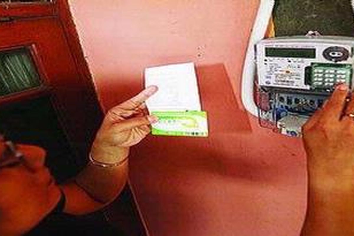 Ibu Agus, seorang pelanggan PLN, memasukkan kode voucer listrik prabayar di meteran listrik rumahnya di kawasan Cipete, Jakarta, Selasa (16/3/2010). Listrik prabayar merupakan alternatif kendali konsumen atas pemakaian listrik, tanpa cemas ada kesalahan pencatatan, pemutusan sambungan, dan denda keterlambatan. 