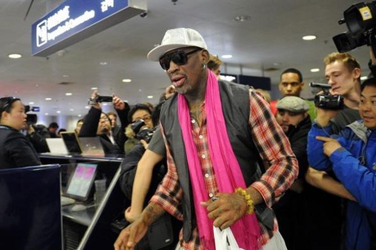 Mantan bintang NBA Dennis Rodman melewati kerumunan wartawan di Bandara Beijing, China. Rodman bersama sejumlah 