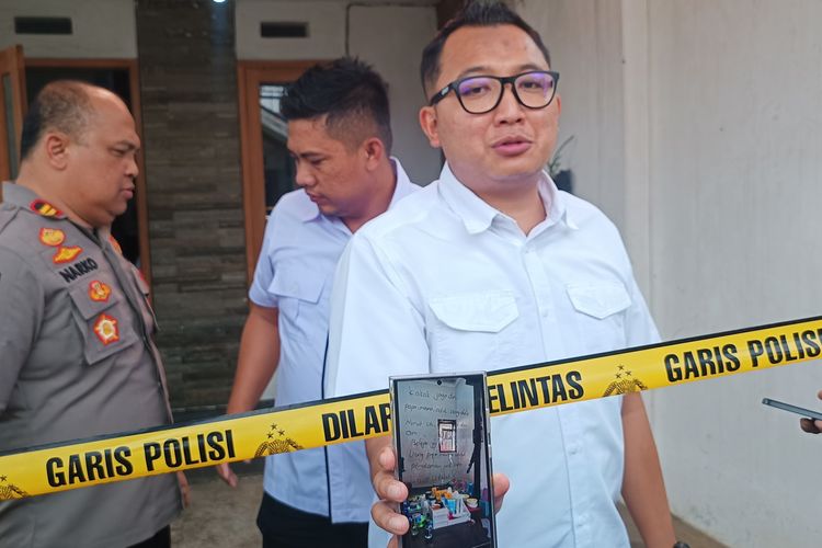Kasatreskrim Polres Malang, AKP Gandha Syah Hidayat saat menunjukan surat wasiat satu keluarga tewas di Dusun Boro Bugis, Desa Saptorenggo, Kecamatan Pakis, Kabupaten Malang, Selasa (12/12/2023) yang ditulis di kaca lemari rias.