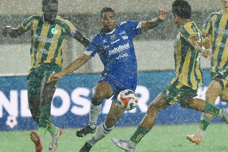 Aksi penyerang Persib Bandung Uilliam Barros ketika dikawal dua pemain PSBS Biak pada laga pekan kesembilan Super League 2025-2026, Jumat (17/10/2025) di Stadion Maguwoharjo, Sleman. 