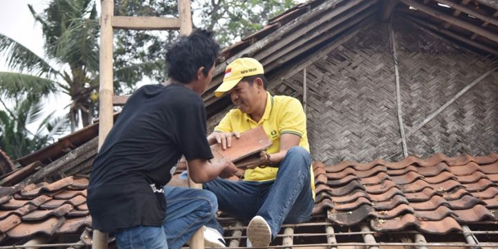 Dedi Mulyadi membantu menurunkan genteng rumah tak layak huni milik pasangan buruh tani, Tama (55) dan Raisah (45) di Karawang.