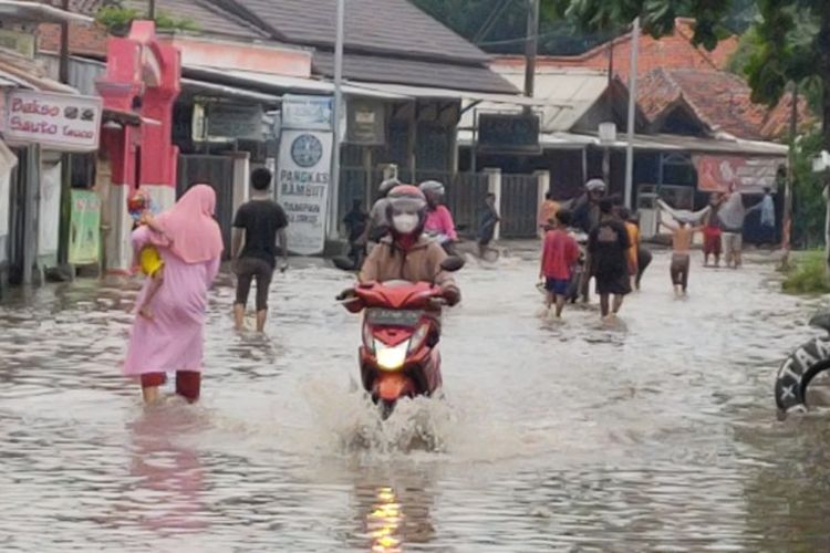Pengendara sepeda motor menerobos banjir di Jalan Ki Hajar Dewantara, Kelurahan Sumurpanggang, Kecamatan Margadana, Kota Tegal, Jawa Tengah, Selasa (23/11/2021)