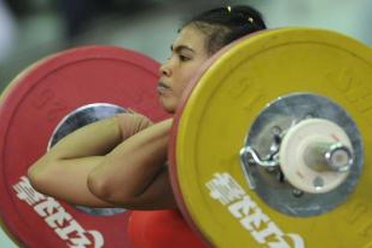 Lifter putri Indonesia, Sri Wahyuni Agustiani melakukan angkatan dengan penuh ketenangan saat tampil dalam laga angkat besi SEA Games 2013 kelas 48 kg di Stadion Theinphyu, Yangon, Myanmar, Jumat (13/12/2013). Dengan total angkatan seberat 188 kg, Sri Wahyuni menjadi perempuan terkuat di kelas tersebut dan berhak dikalungi medali emas.