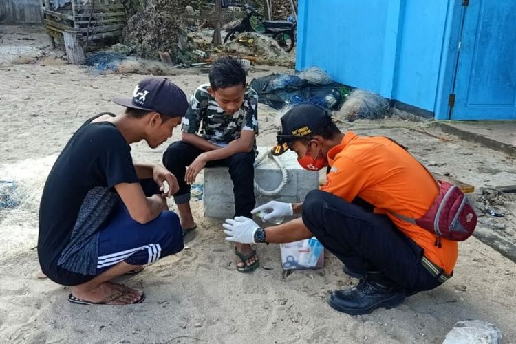 Petugas SWR Satlinmas Wilayah II Gunungkidul Sedang Memberi Obat Kepada Pengunjung pantai yang Tersengat Ubur-ubur Minggu (9/8/2020)