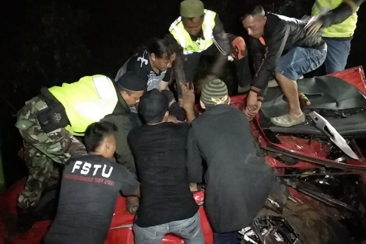 Petugas Kepolisian dan TNI dibantu warga sekitar sedang mengevakuasi satu keluarga tewas dalam mobil Agiya yang terjepit dalam kecelakaan maut di Tanjakan Gentong, Tasikmalaya, Sabtu (19/1/2019) dini hari tadi. 