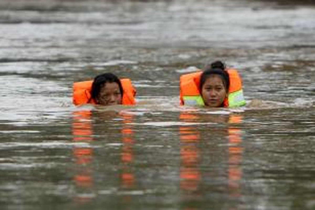 Warga melintasi banjir setinggi satu meter di Bukit Duri, Jakarta Selatan, Senin (13/1/2014). Sejumlah wilayah di Jakarta terendam banjir akibat curah hujan yang tinggi dan air kiriman dari Bogor. TRIBUNNEWS/HERUDIN