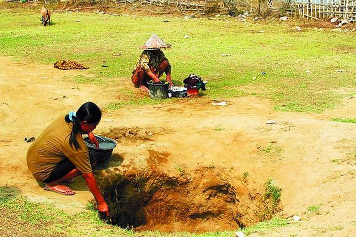Warga Lontar, Kecamatan Tirtayasa, Kabupaten Serang, Banten, Senin (28/7), memanfaatkan air di lubang galian di lapangan untuk mencuci dan kebutuhan lainnya. Selama musim kemarau, warga harus menunggu selama berjam-jam untuk memperoleh dua ember air dari lubang galian tersebut.  