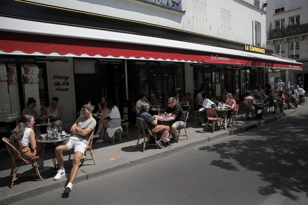 Orang-orang duduk di kafe teras Paris pada Selasa (2/6/2020), karena kafe dan restoran tidak diizinkan melayani pelanggan di dalam ruangan.  Presiden Perancis Emmanuel Macron pada Minggu (14/6/2020) mengumumkan Paris termasuk zona hijau virus corona, sehingga kafe-kafe dan restoran diizinkan buka lagi sepenuhnya.