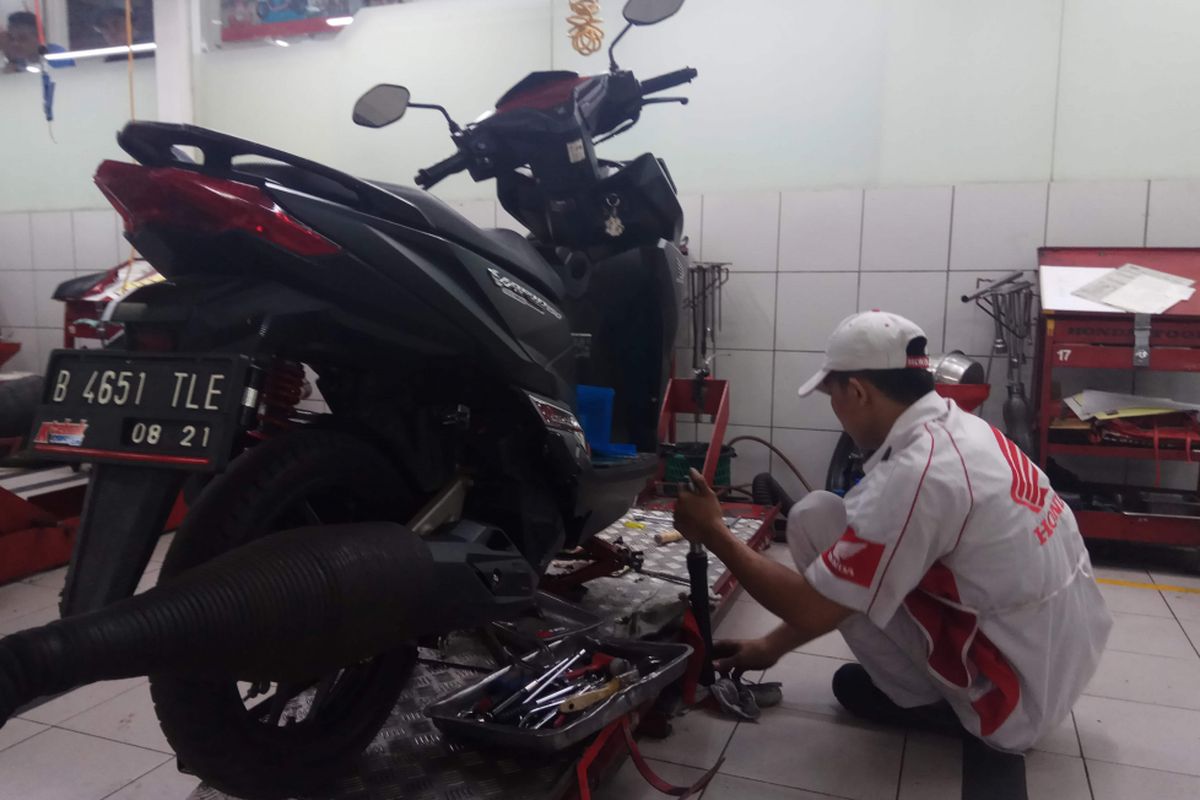 Teknisi di Bengkel Astra Motor Center Jakarta yang ada di bilangan Dewi Sartika, Jakarta Timur, tengah mengecek kondisi skutik milik pelanggan, Selasa (2/1/2018).