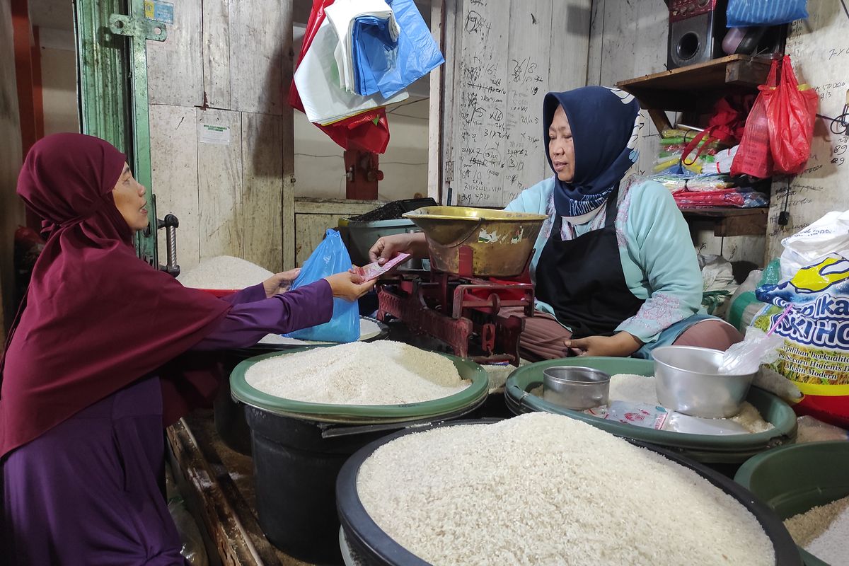 Salah satu pedagang beras di pasar tradisional Bintoro Demak, sedang melayani pelanggan, Senin (4/3/2024). (KOMPAS.COM/NUR ZAIDI)