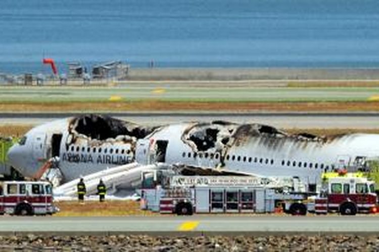 Bangkai pesawat Boeing 777 milik Asiana Airlines teronggok di salah satu sudut bandara internasional San Francisco, sementara para petugas melakukan investigasi.